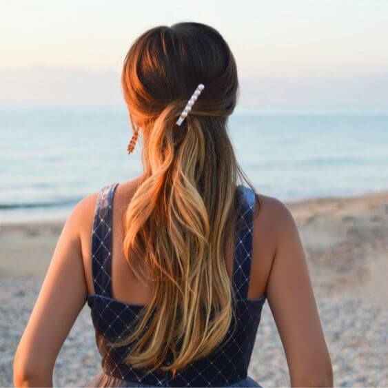 woman at the beach with clean fresh hair using dry shampoo